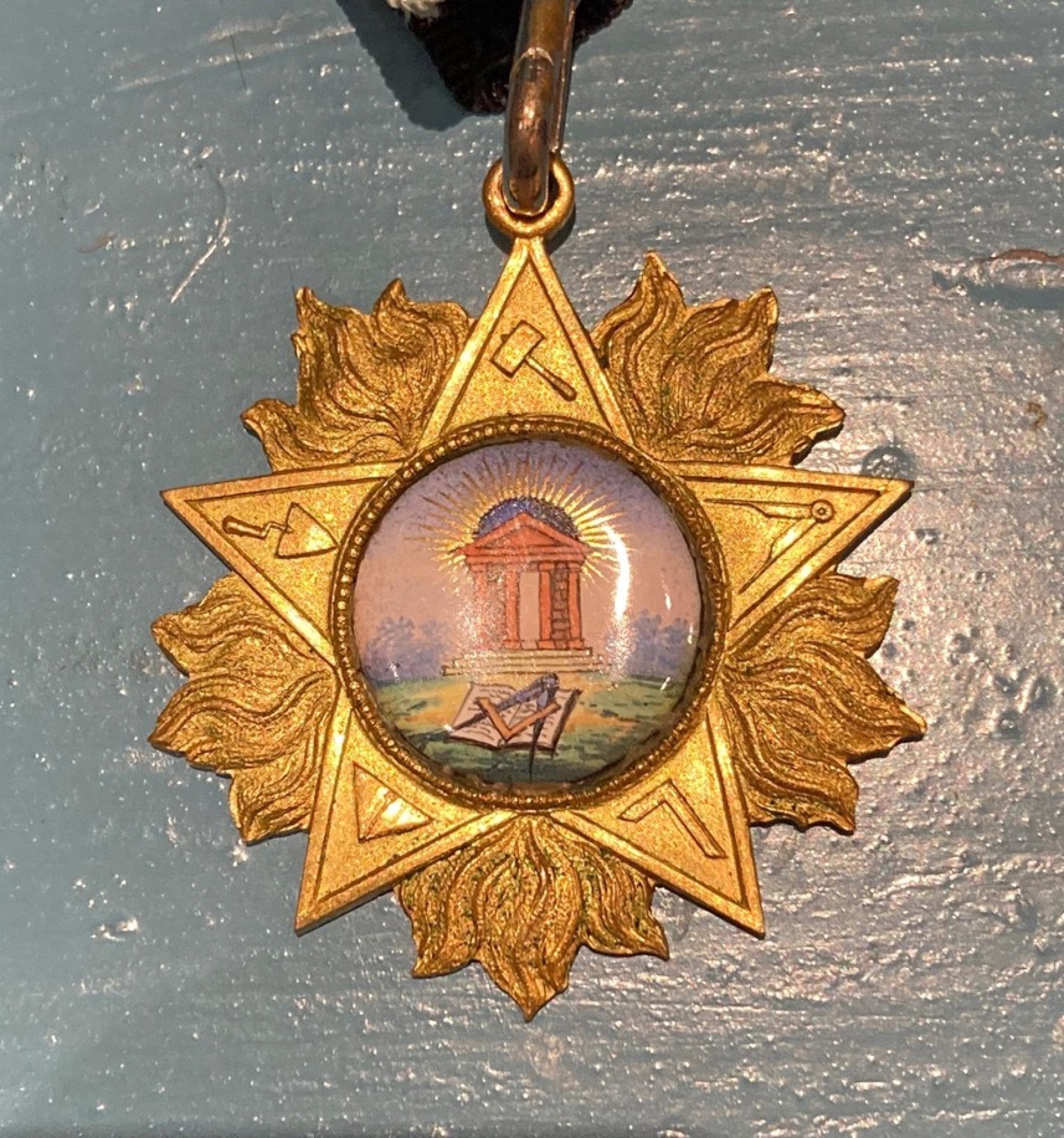 Ordensstern der Loge: ein goldener Strahlenstern mit dem Bild eines Tempels im Zentrum